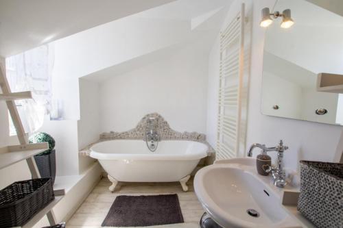 La maison de lolo et marco في Champagnac-de-Bélair: حمام أبيض مع حوض استحمام ومغسلة