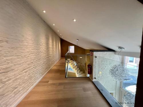 a hallway with a brick wall and a staircase at La villa d'exception Piscine Jacuzzi Sauna Hammam in Landen