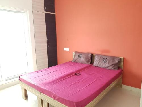 a bed in a room with an orange wall at C Suite- Cannes in Kammasandra