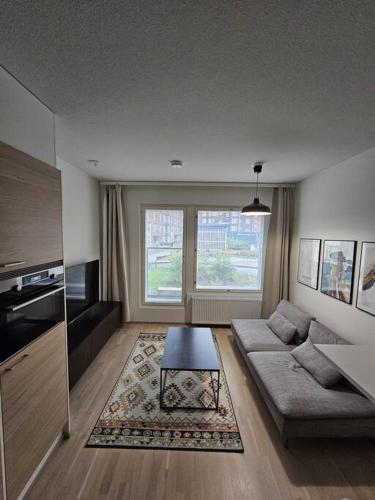 a living room with a couch and a table at Modern City Apartment nearby Airport in Vantaa