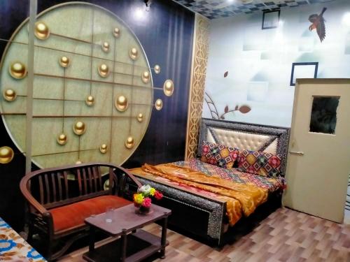 a room with a bed and a chair and a table at New Faizan Hotel in Lahore