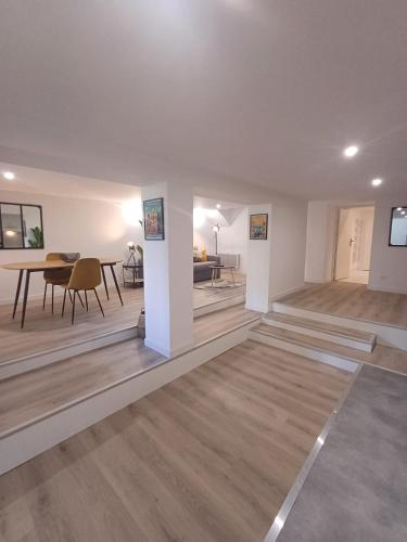 un salon avec une table et une salle à manger dans l'établissement le loft du canal, 2 lits, baignoire balnéo, wifi, à Agen