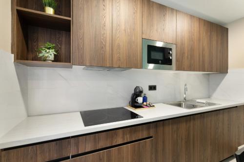 a kitchen with a sink and a microwave at Atw Suites Canteras in Las Palmas de Gran Canaria