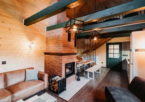 a living room with a brick fireplace and a couch at Zielony Jawornik in Jawornik Stary