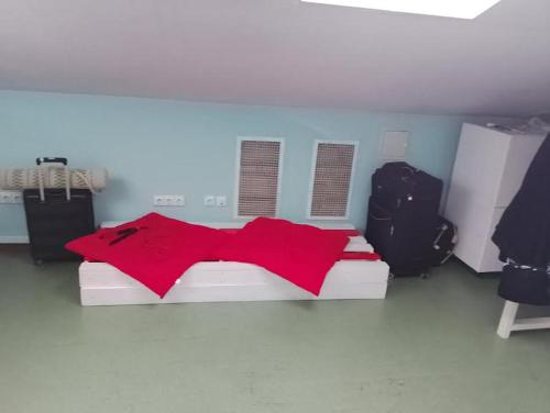 a bedroom with a bed with a red shirt on it at Мансарда- укриття поруч, 10 метрів in Kyiv