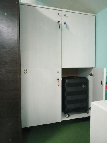 a white cabinet with a black chair in a room at Мансарда- укриття поруч, 10 метрів in Kyiv