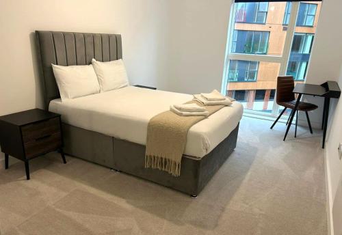 a bedroom with a bed and a desk and a window at 1 Bed Serviced Apartment Bracknell with parking 5 mins from station in Bracknell
