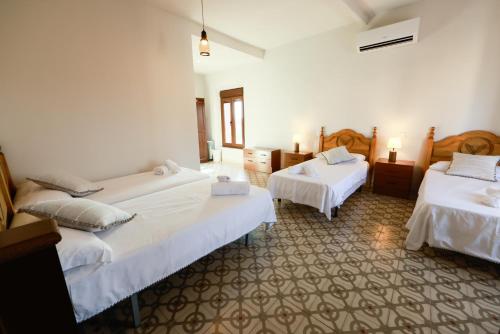 a hotel room with two beds and two tables at Teralba 1 Casa Rural in La Calzada de Oropesa