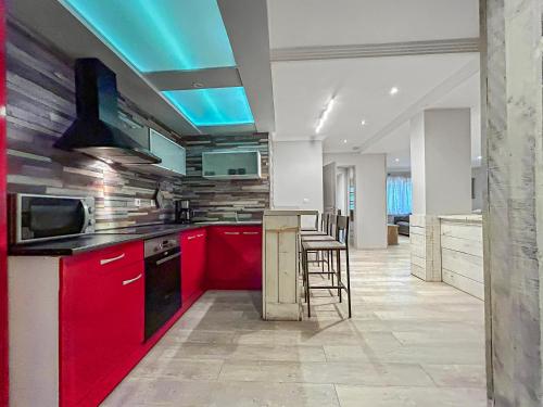 une cuisine avec des armoires rouges et un plafond bleu dans l'établissement Grand Salon Cosy, proche centre Dijon & garage 2p, à Dijon