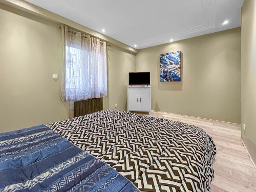 une chambre avec un grand lit et une télévision dans l'établissement Grand Salon Cosy, proche centre Dijon & garage 2p, à Dijon