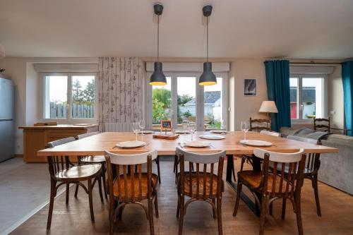 une cuisine et une salle à manger avec une table et des chaises en bois dans l'établissement Ty Eole Maison Tout Confort 10p, à Quiberon