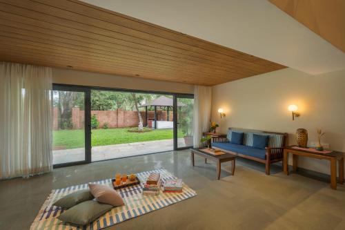 a living room with a blue couch and a table at SaffronStays Red Brick House, Panchgani - rustic villa with huge lawn and terrace in Panchgani