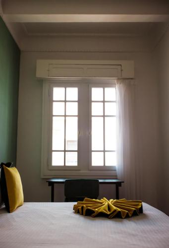 a yellow robe laying on a bed in front of a window at Appartements Balima Harcourt DeLuxe in Rabat
