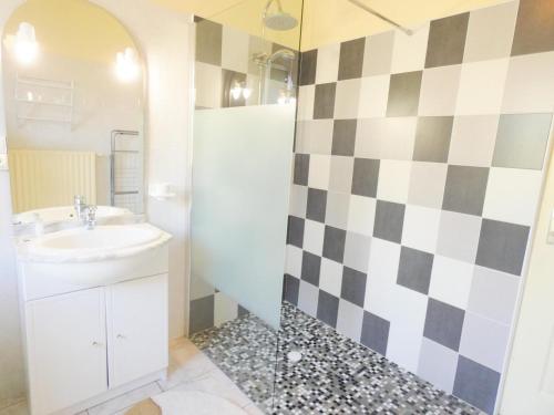 La salle de bains est pourvue d'un lavabo et d'un mur en damier. dans l'établissement Les cannas, à Quartier-Neuf