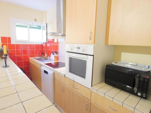 une cuisine avec une cuisinière et un micro-ondes dans l'établissement Les cannas, à Quartier-Neuf