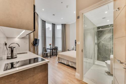 a hotel room with a bed and a bathroom at Cleveland Residences Chelsea in London