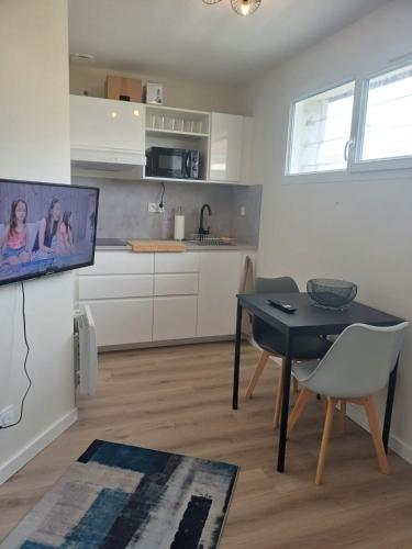un salon avec une table et une cuisine dans l'établissement Le studio du canal, 2 pers, wifi, à Agen