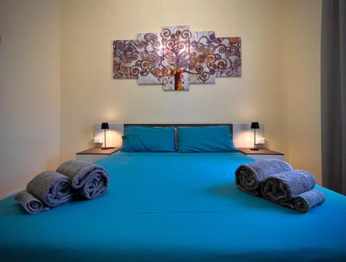 a bedroom with a blue bed with towels on it at Civico 16 in Nettuno