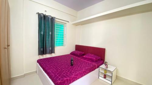 a red bed in a white room with a window at C Suites - Fallon in Bengaluru