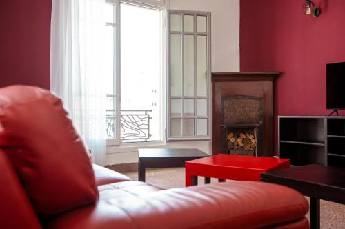 a red living room with a red couch and a fireplace at Appartements Balima Harcourt DeLuxe in Rabat
