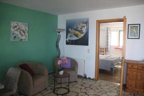 a living room with two chairs and a lamp at Villa Bettina 1st floor in Afionas