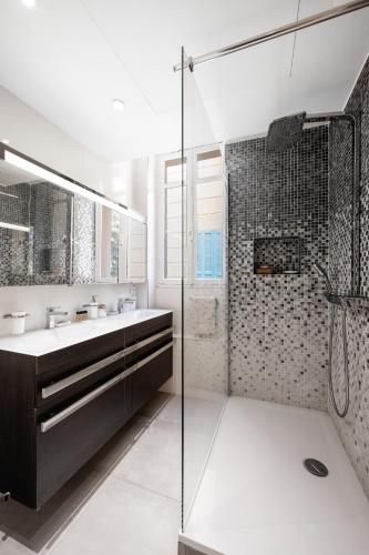 une salle de bain avec une douche en verre et un lavabo dans l'établissement Appartement d Exception, Spacieux et Lumineux, avec Balcon et Vue Mer, à Villefranche-sur-Mer