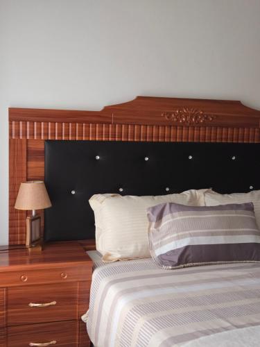 a bedroom with a large wooden headboard and a bed at Dk Casa in Lusaka