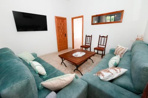 a living room with a blue couch and a table at Casa Rural Teralba 2 in La Calzada de Oropesa