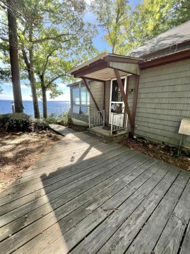 a porch of a house with a wooden deck at DOCKSIDE RETREAT LIMIT 14 home in North Sebago