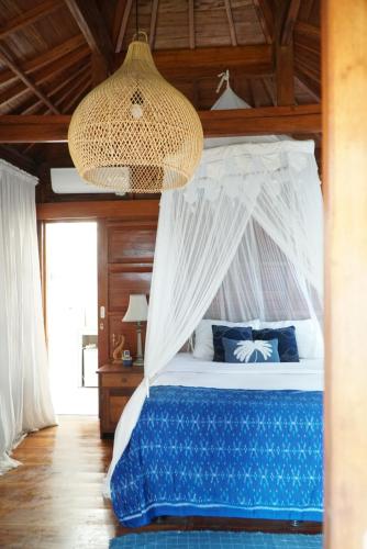 a bedroom with a bed with a canopy at Berawagaya Bungalows in Dalung