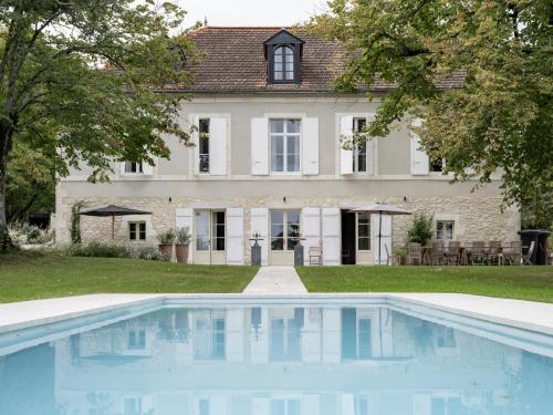 une maison avec une piscine devant une maison dans l'établissement La Grande Maurague, à Condom