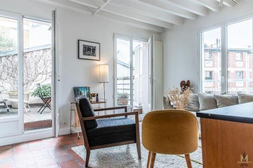 un salon avec un canapé, une table et des chaises dans l'établissement Montmartre, Patio! Sacré-Coeur! Stylish duplex!, à Paris