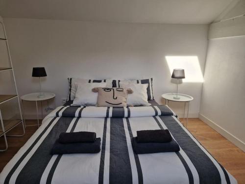 Cette chambre comprend un grand lit et 2 tables. dans l'établissement Appartement T2 Le central, à Chalon-sur-Saône