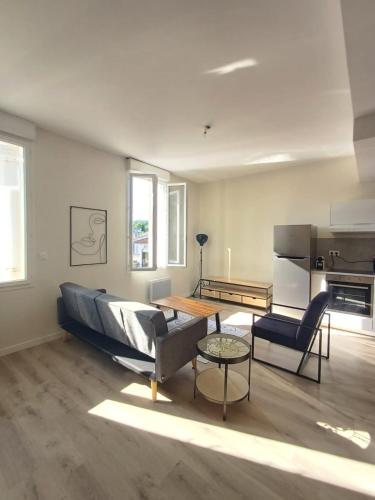 un salon avec un canapé et une table dans l'établissement Superbe T5 , 4chs, 8pers, parking privé, wifi, à Agen