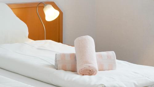 a pair of towels sitting on a bed at Hotel Am Weyerhof in Kerpen