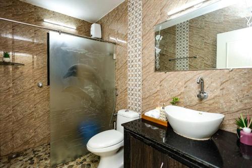 a bathroom with a sink and a toilet and a shower at Stays By Amira in Bardez