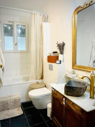 une salle de bain avec un lavabo, des toilettes et un miroir dans l'établissement Petit Montmartre dans le 20e à Paris, à Paris