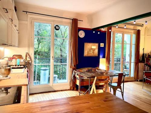 une cuisine avec une table et une salle à manger dans l'établissement Petit Montmartre dans le 20e à Paris, à Paris