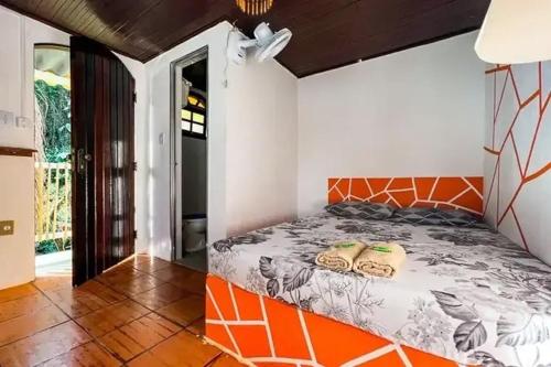 a bedroom with an orange and white bed in a room at Pousada Ponta da Ilha, Ilha Grande, Angra dos Reis in Angra dos Reis