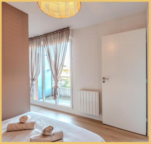 une chambre avec un lit et une grande fenêtre dans l'établissement Chez Matias I T3 I Ville-la-Grand, à Annemasse