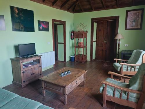 a living room with a tv and a coffee table at Casa Rural de Abuelo in Garafía