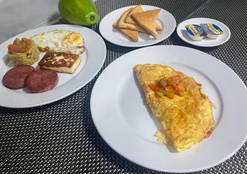 a table with plates of breakfast foods on them at Gaia Residence Deluxe in San Felipe de Puerto Plata