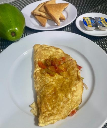 a white plate with an omelet and some chips at Gaia Residence Deluxe in San Felipe de Puerto Plata
