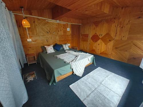 a bedroom with a bed in a wooden cabin at Seasons By Hostalgic in Jibhi