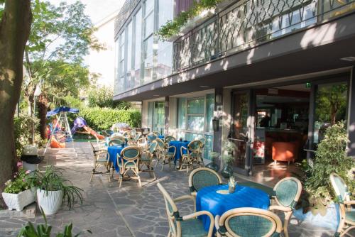 un gruppo di tavoli e sedie all'esterno di un edificio di Hotel Mirage a Bellaria-Igea Marina