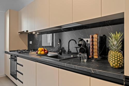 a kitchen with a sink and a counter with fruit on it at Studio Luxury Cortina North Residence Pipera in Voluntari