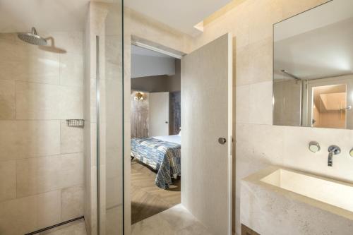 a bathroom with a sink and a bed in a room at Hotel Palazzo Manfredi – Small Luxury Hotels of the World in Rome