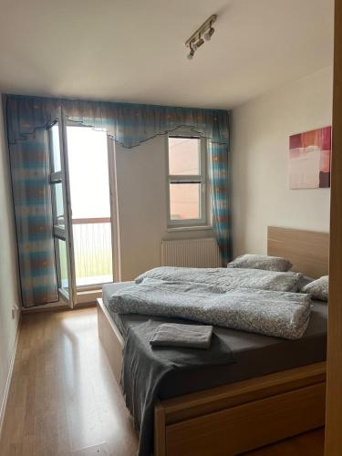 a bedroom with two beds and a large window at Ski Apartmán Salomon in Loučná pod Klínovcem