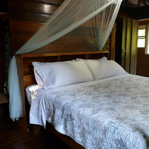 a bedroom with a bed with a mosquito net at Barton Creek Unique Resort in Sayab Camp