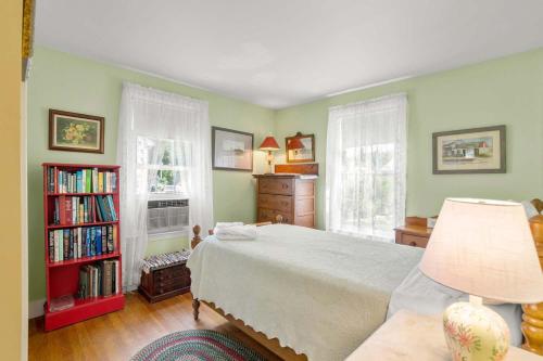 a bedroom with a bed and a book shelf at On the Chatham Loop - 1 Min to the Beach in Chatham